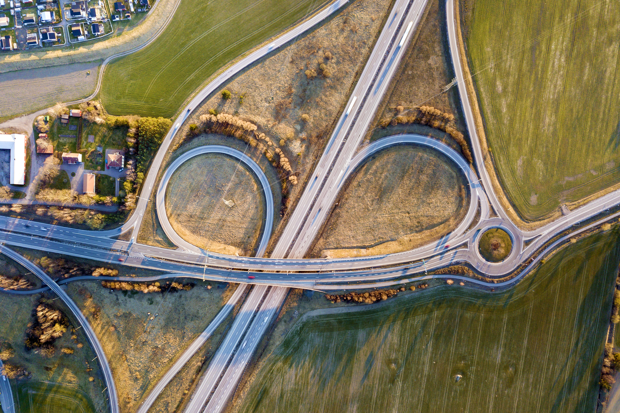 Aerial top view of modern highway road intersection, house roofs